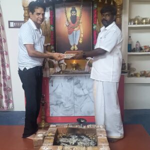 Devotee holding sacred Nadi astrology palm leaf at Sri Mahasiva Agathiya Sukshama Nadi Jothidam, Vaitheeswaran Koil.